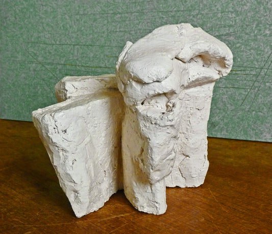 a couple of white sculptures sitting on top of a wooden table