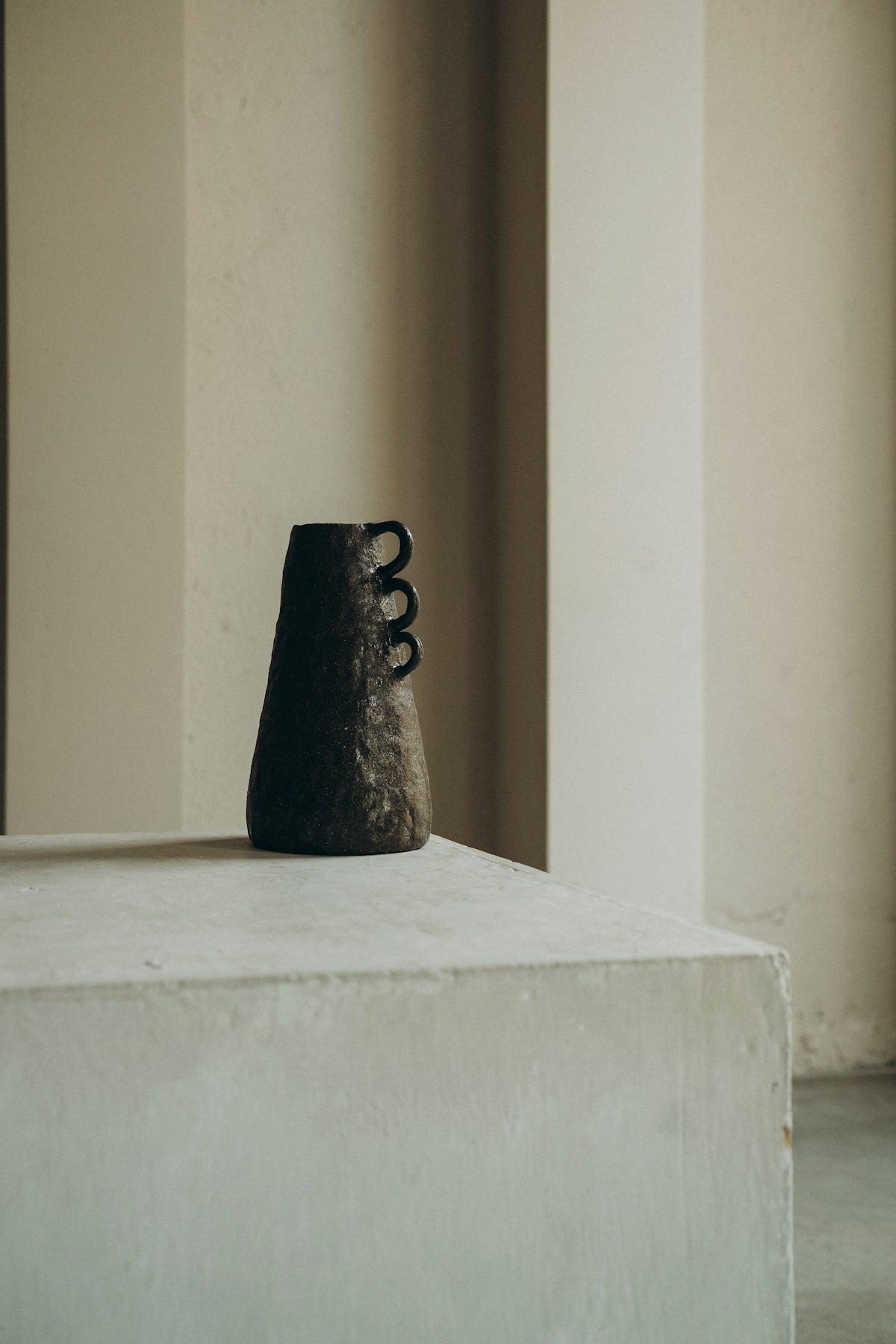 black ceramic figurine on white concrete table