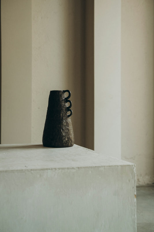 black ceramic figurine on white concrete table