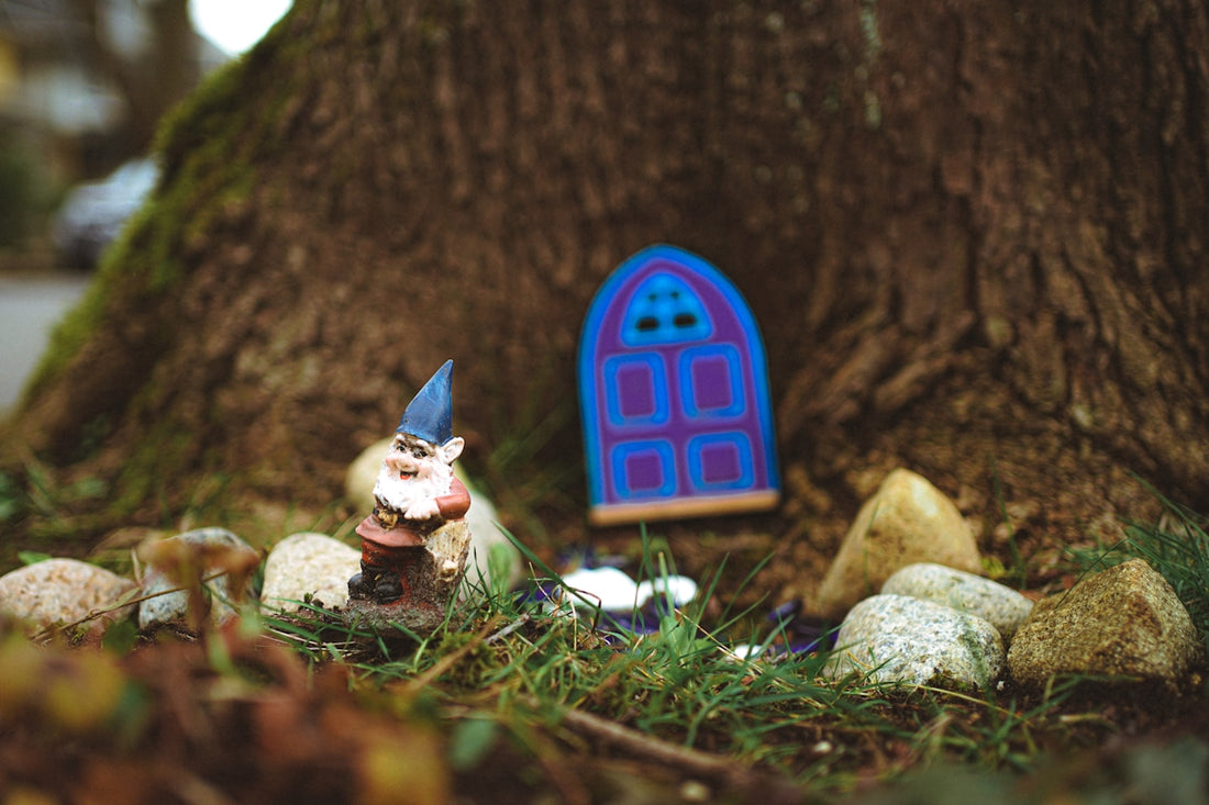 a gnome figurine in front of a tree with a blue door