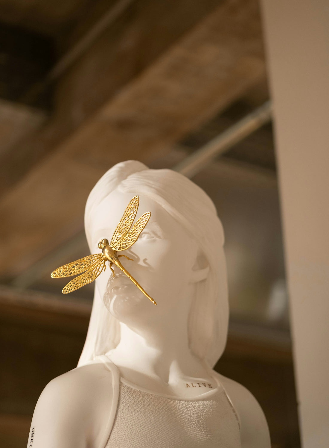 A sculpture has a golden dragonfly.