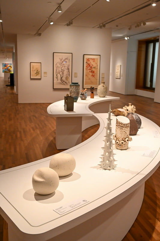 Art gallery display with ceramic sculptures and paintings.